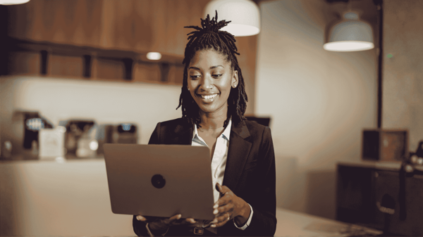 Femme dans son environnement de travail avec un ordinateur portable à la main