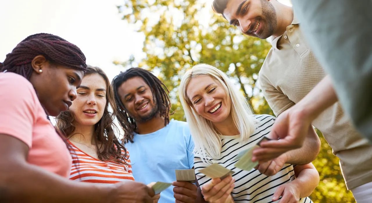 Un groupe de personne tire des cartes dans une activité de team building