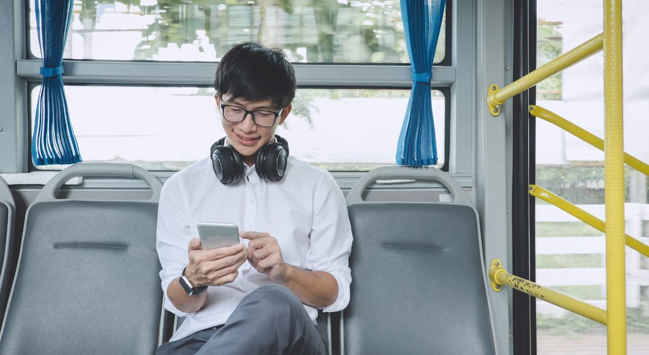 Un homme utilise son smartphone dans les transports en commun