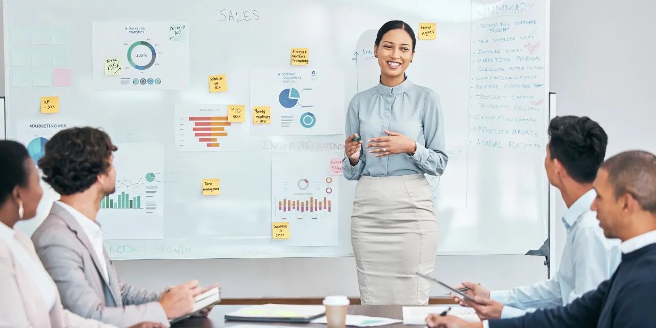 Une formatrice explique des statistiques à des commerciaux
