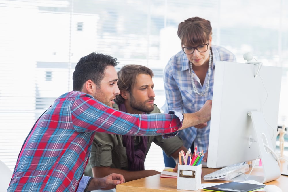 Team of designers working together on a computer