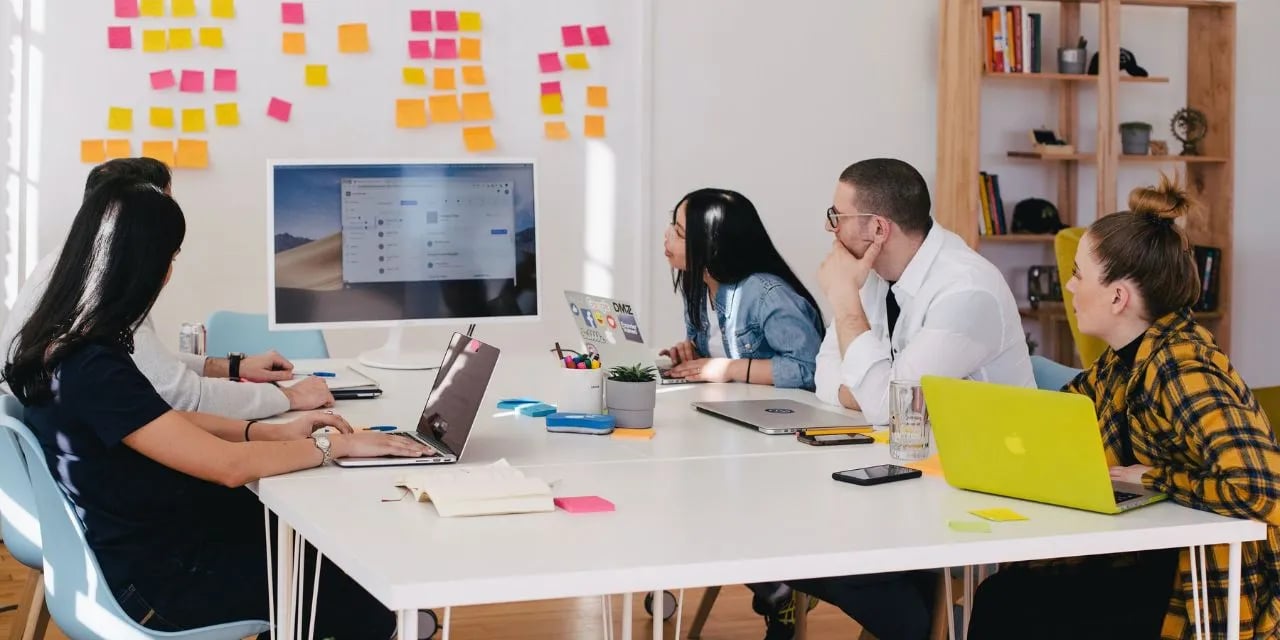 Group of people in a meeting looking at a presentation on screen