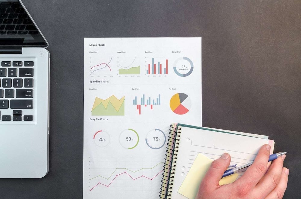 data report on desk next to person's hand