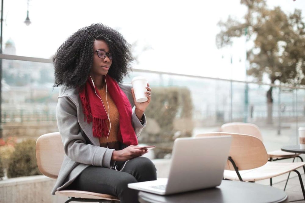 woman using smartphone and laptop to access lms